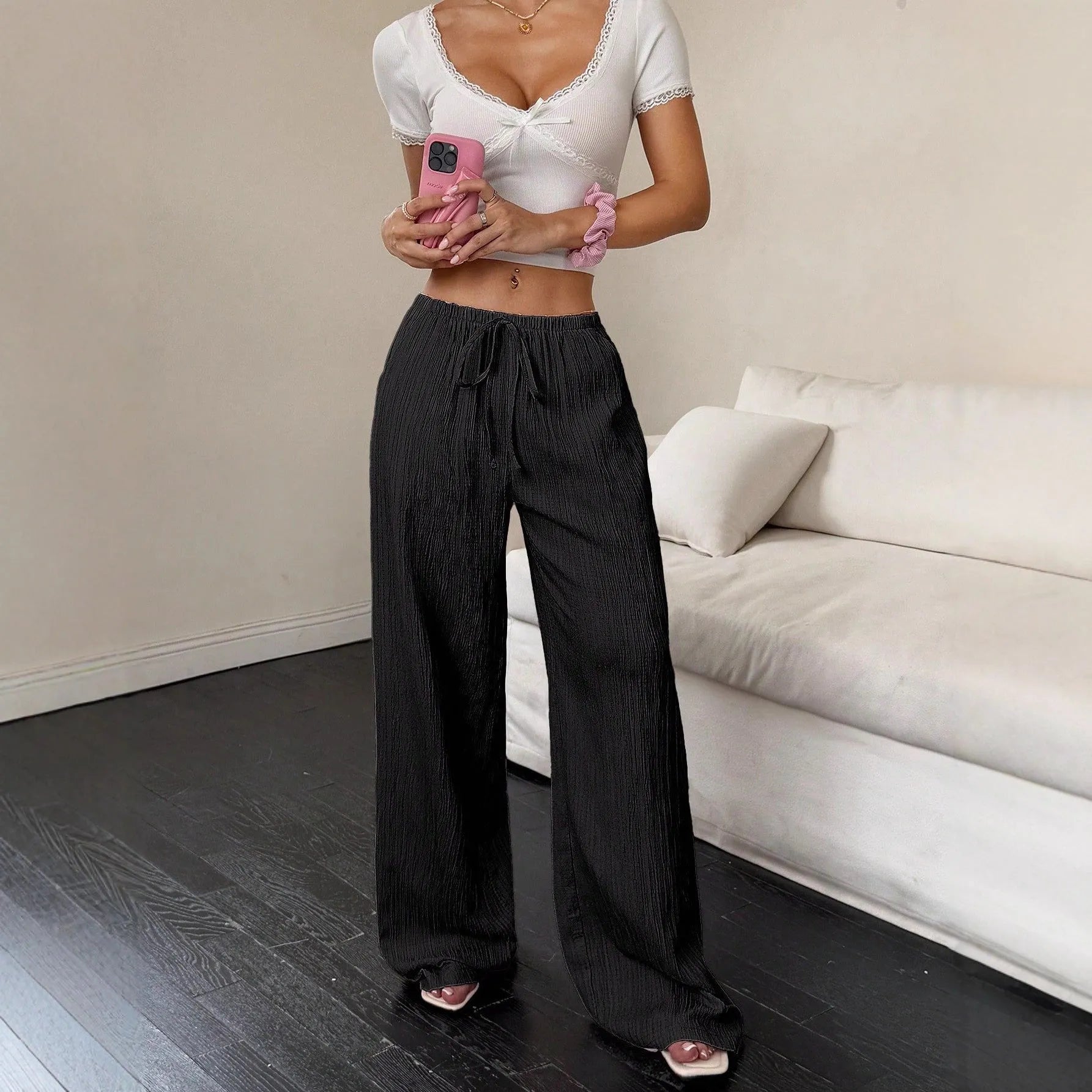 Women's wide-leg black trousers with a lace-up detail on the mid-rise waist