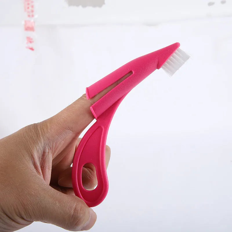 Red and white pet finger toothbrush with silicone bristles shown next to a ruler for scale.