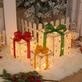 Set of three lighted Christmas gift box decorations with bows and LED lights for holiday displays