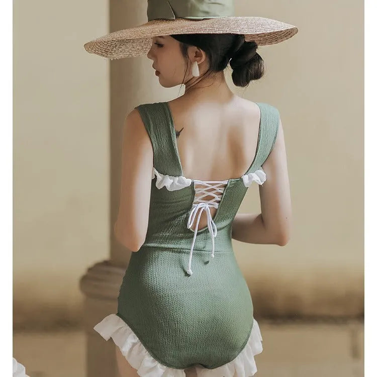 Black high-waisted one-piece swimsuit on a mannequin, showing quick-dry fabric and slimming cut.