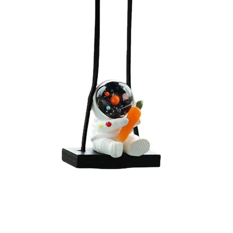 Resin astronaut car pendant showing cartoon astronaut designs including telescope, red flag, and radish variations