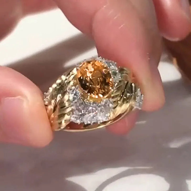 Gold-coloured embossed feather ring with geometric shape and inlaid yellow zircon stone