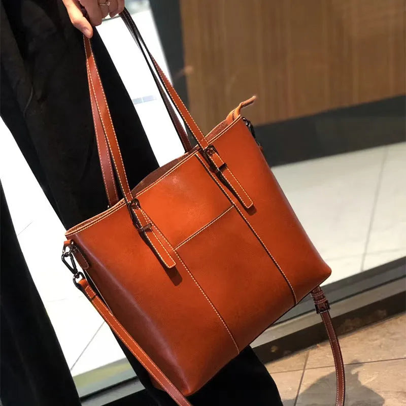Brown genuine leather retro women's tote bag with multiple zipper pockets and three shoulder straps.