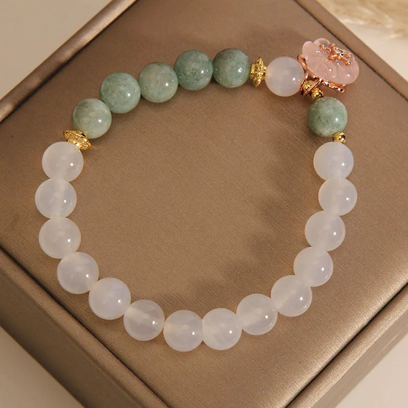 Emerald agate bracelet with white jade flower beads and pink accents on wrist