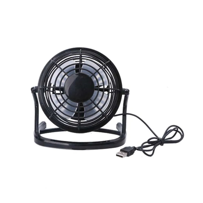 Mini black USB desk fan with adjustable tilt, shown on a desk next to a laptop.
