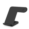 Black or white Qi wireless charging pad for mobile phones on a desk.