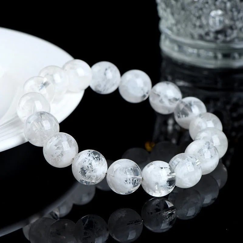Geometric natural blizzard snowflake crystal women's bracelet with round beads on a white background.