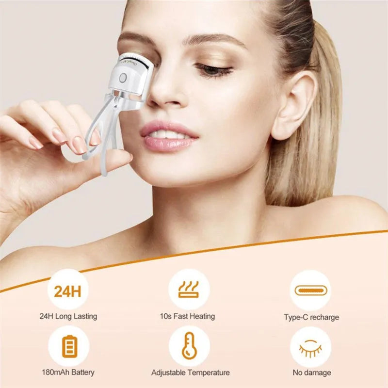 White USB rechargeable heated eyelash curler with dual temperature settings shown on a pink background.
