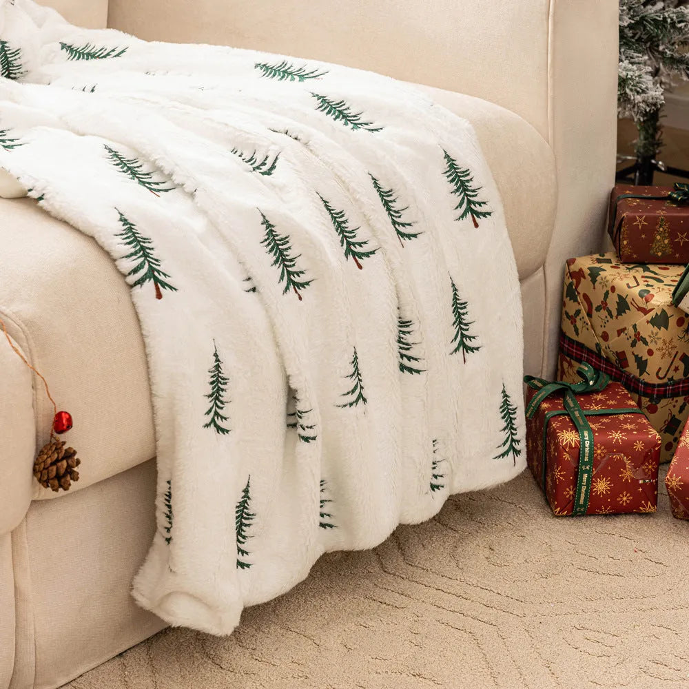 White Christmas plush sofa blanket with embroidered tree motif on a living room sofa