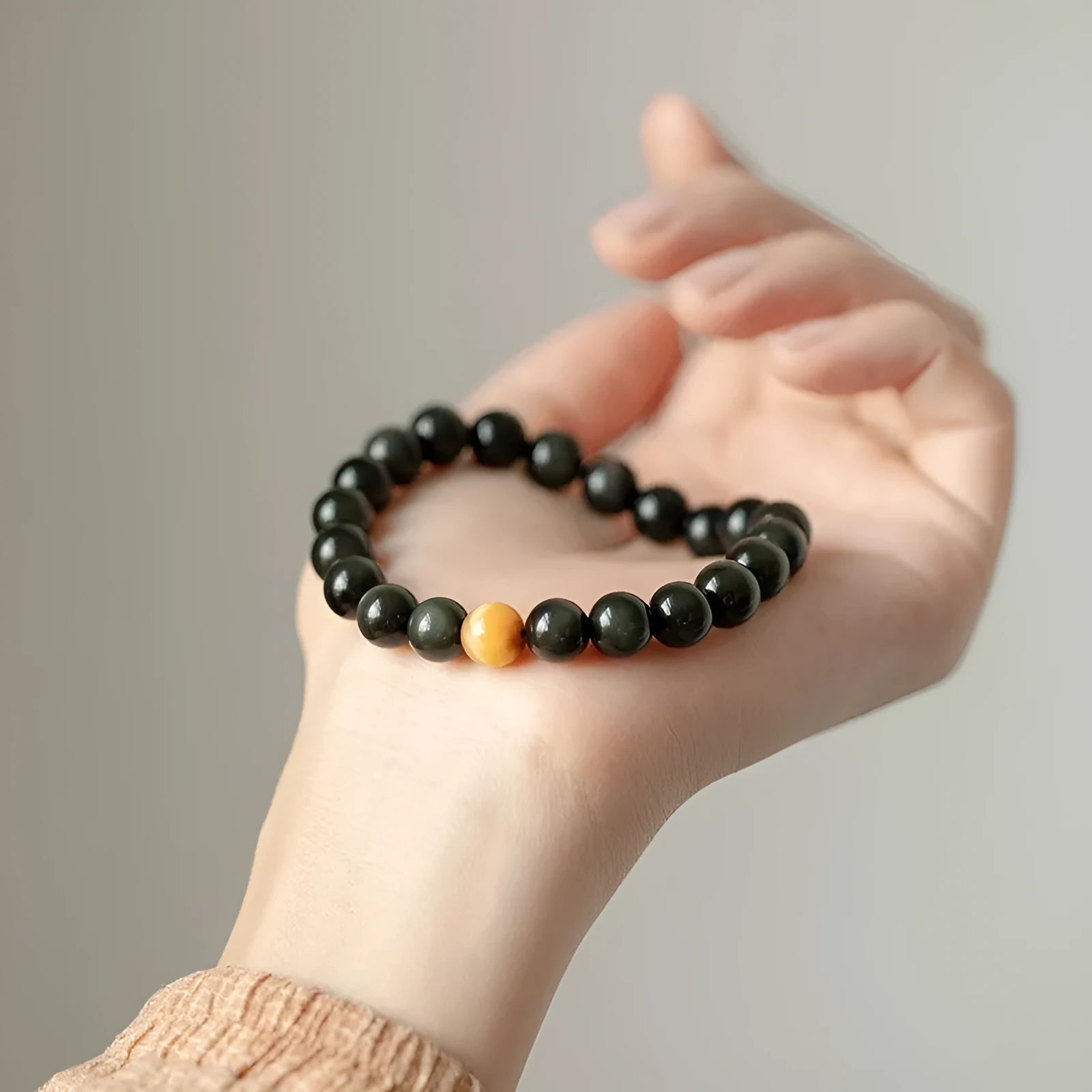 Black geometric obsidian bead bracelet shown in three size options: 6mm, 8mm, and 10mm beads.