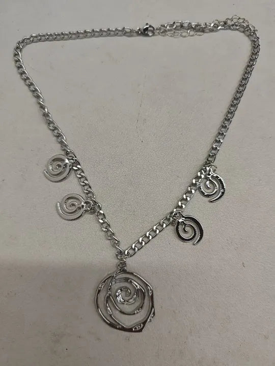 Gold spiral donut charm jewellery set showing necklace, bracelet and earrings on a white background