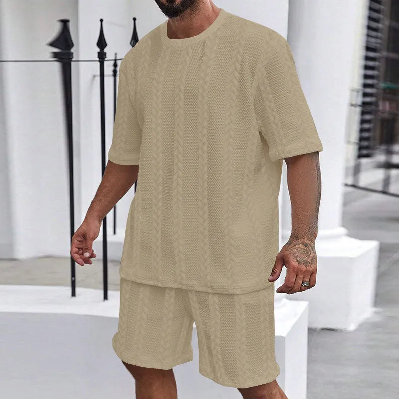 Knitted solid colour short sleeve pullover and matching shorts laid flat.