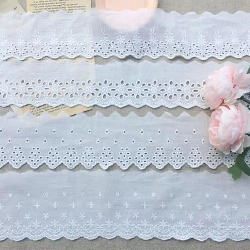 Cotton embroidered lace trim on roll showing cutout pattern, with width measurement examples