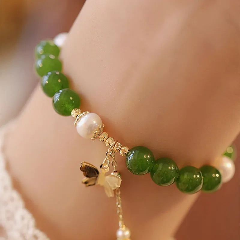 Close-up of a green chalcedony bracelet with round geometric beads on a wrist.