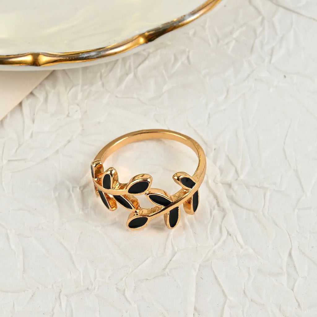 Gold geometric leaf and flower shape acrylic ring for women on index finger.