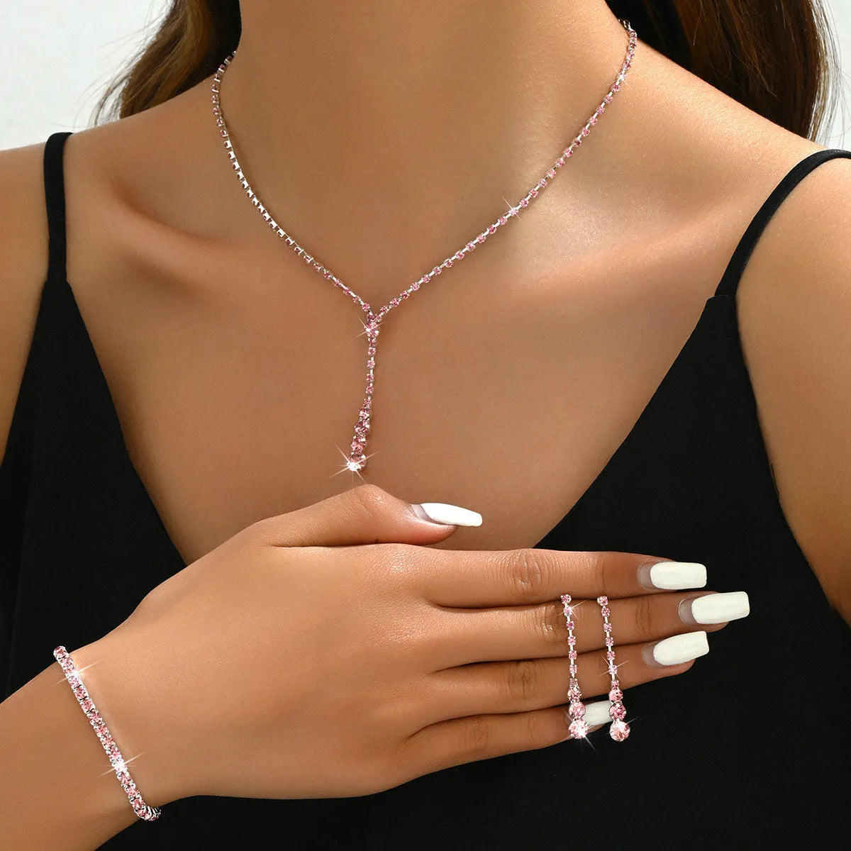 Three-piece bridal jewellery set showing necklace, bracelet and earrings with rhinestone pendant and heart-shaped design