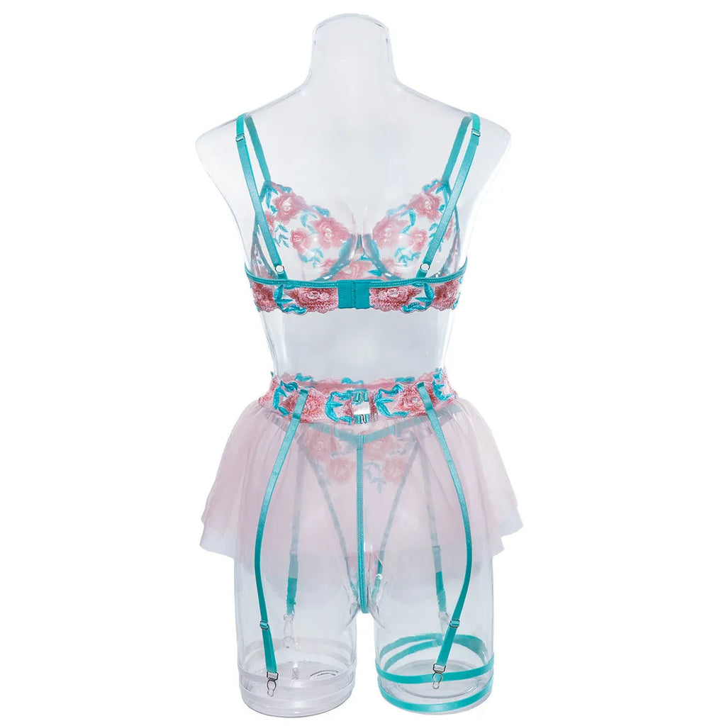 Pink embroidered women's bikini set with a matching mesh pettiskirt laid flat.