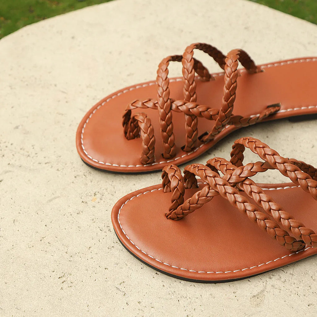 Women's woven flat sandals with a clip-toe design in black, white, or brown.