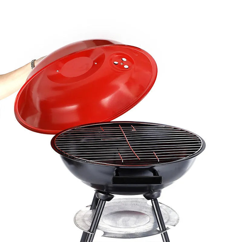 Portable iron barbecue oven with 14-inch apple stove design on a table outdoors.
