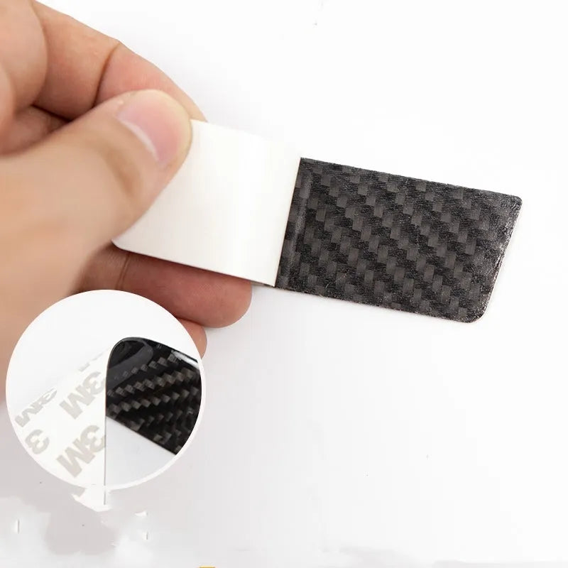 Four clear carbon fibre adhesive door handle protection patches for Tesla Model S interior.