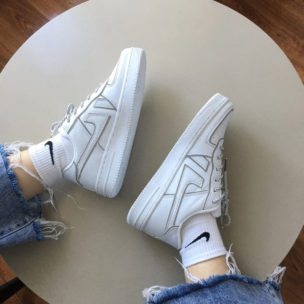 Reflective white unisex low top sneaker with lace up closure, synthetic leather upper, and TPR sole