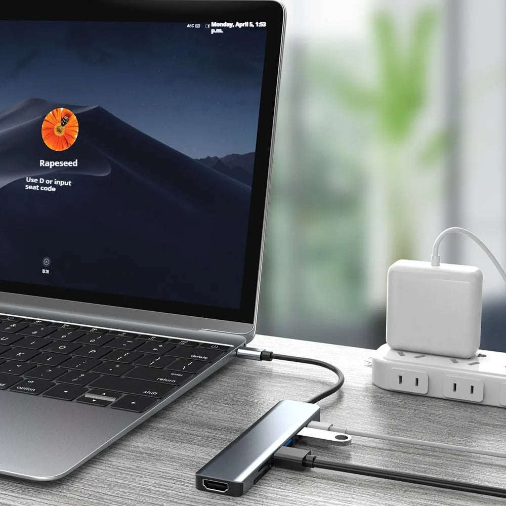 Seven-port USB-C hub expander with short cable shown next to a laptop.