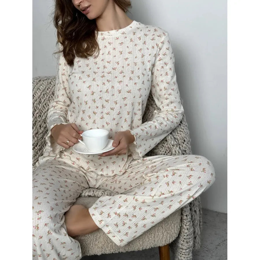 White floral print women's suit with bell sleeve top and wide-leg trousers laid flat