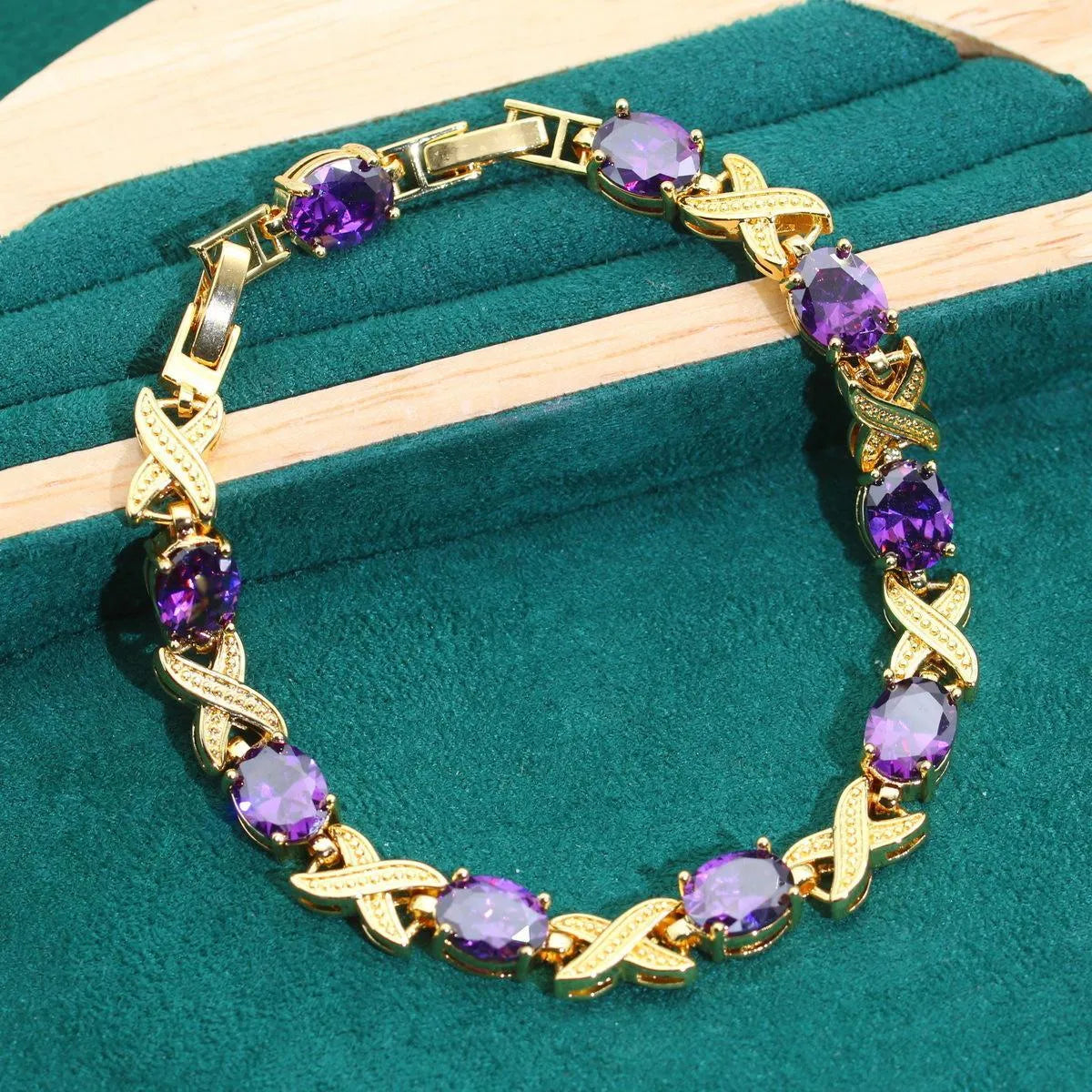 Gold plated necklace, earrings, bracelet, and ring set with blue cubic zirconia stones.