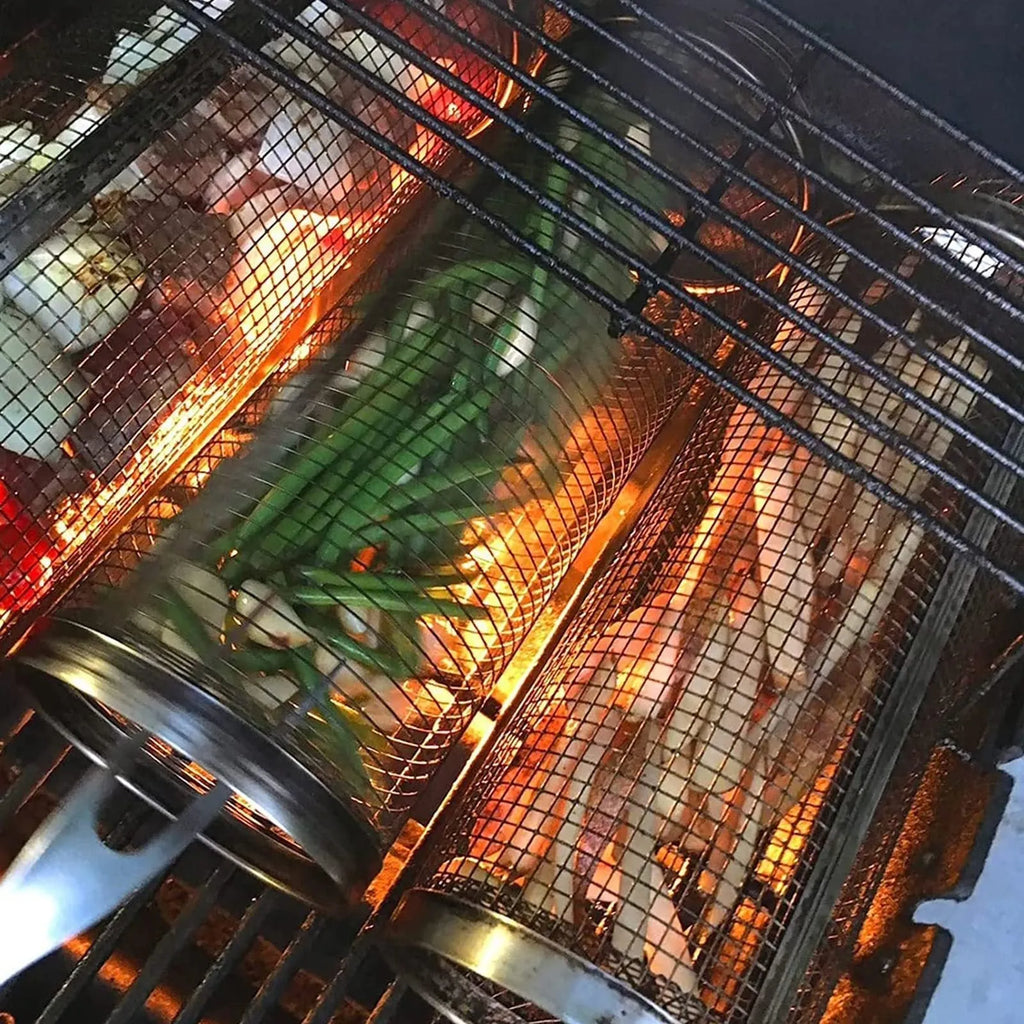 Round silver metal rolling barbecue basket with wire mesh and a hook, shown with vegetables inside on a grill.