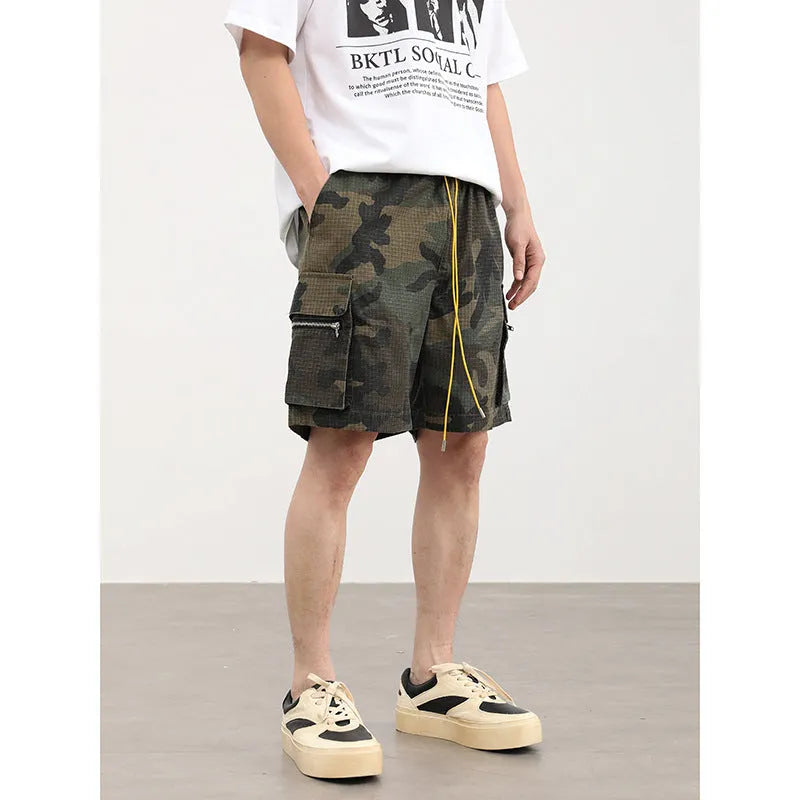 Men's camouflage-coloured cropped shorts with multiple three-dimensional cargo pockets on the legs.