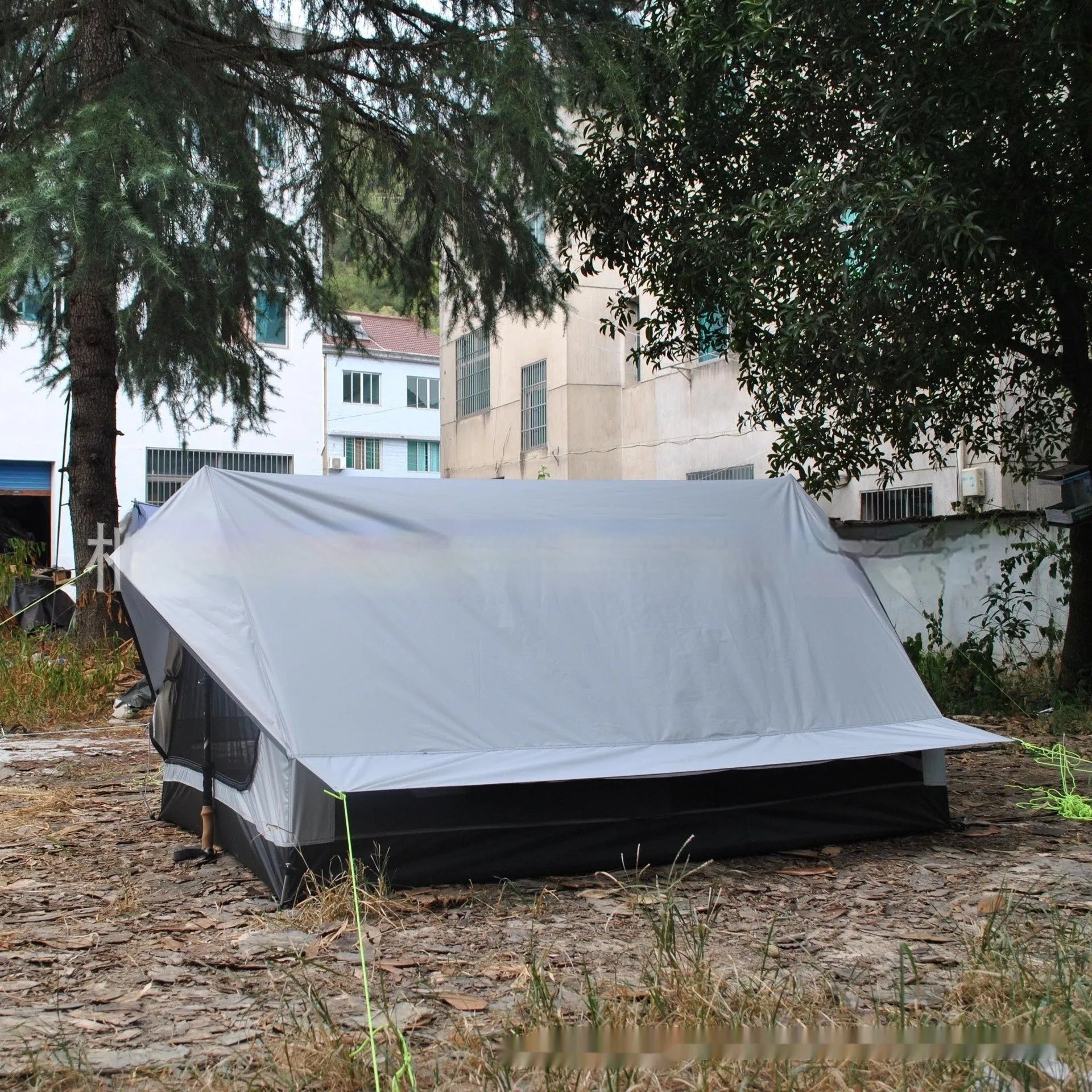 Brown A-line pole-free tent erected with hiking canes showing 2-3 person capacity and waterproof fabric construction