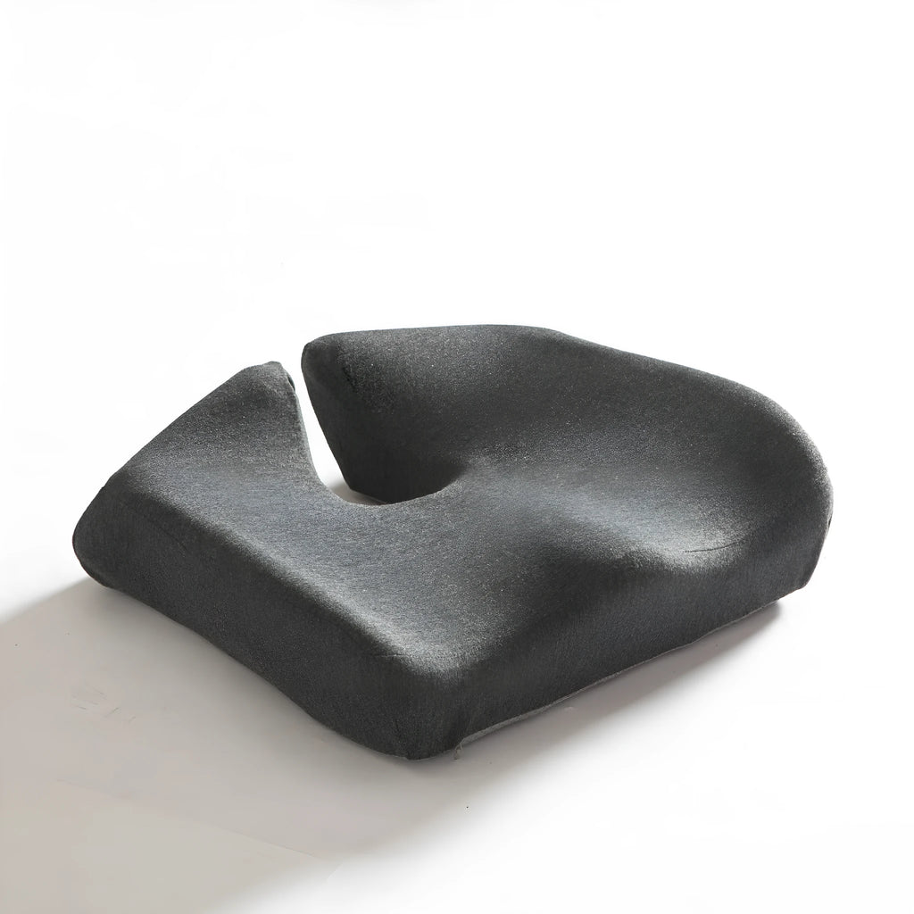 A black memory foam office chair cushion measuring 36 by 40 centimetres on a desk chair.