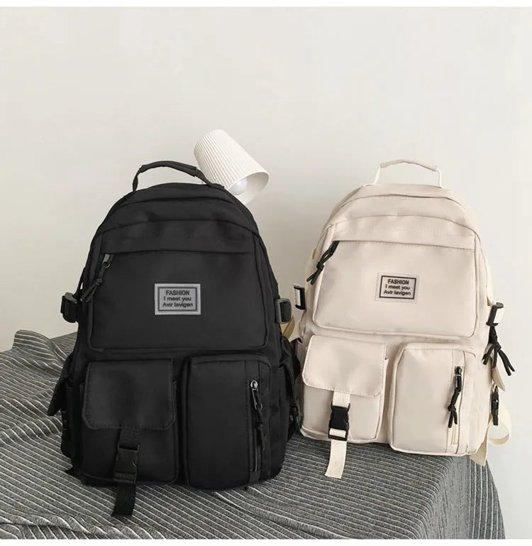 Black and white nylon student backpack with laptop compartment and 3D pockets.