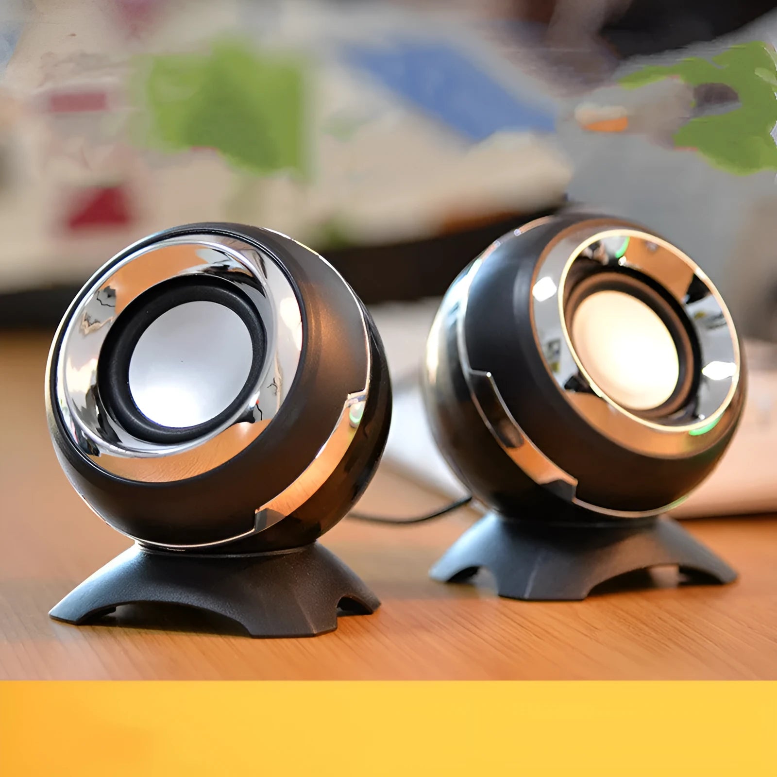 Compact black and gold USB-powered desktop speaker beside a laptop.