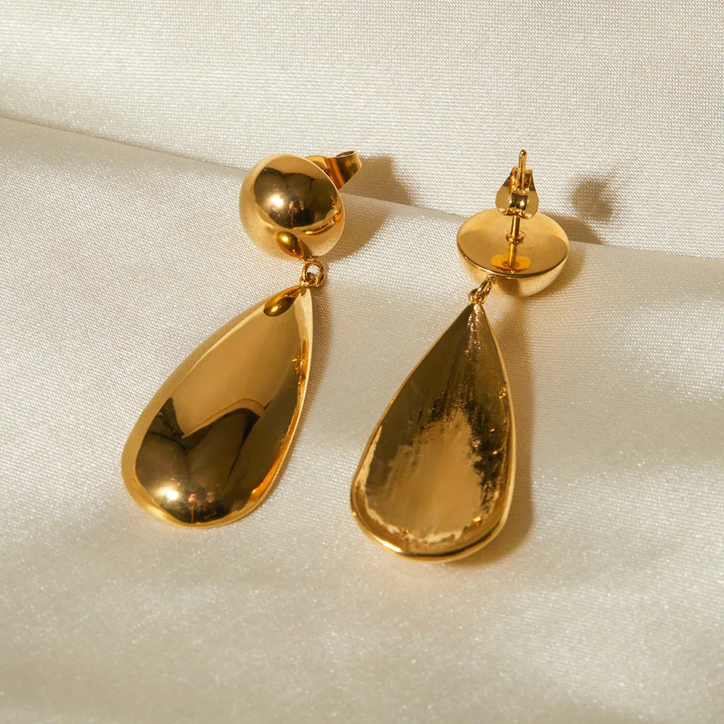 Gold coloured geometric hemisphere earrings with a dangling water drop pendant, made from stainless steel.