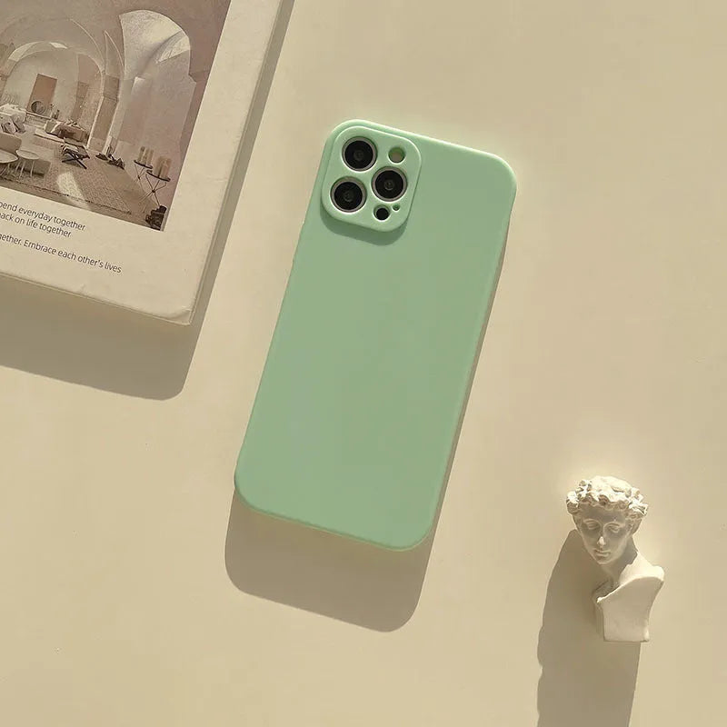 Frosted matte silicone phone case for iPhone 14 on a table, showing the slate blue colour option.