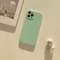 Frosted matte silicone phone case for iPhone 14 on a table, showing the slate blue colour option.