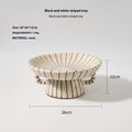 Black and white striped synthetic resin fruit plate on a wooden surface.