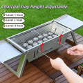 Small foldable portable steel charcoal grill for outdoor use.