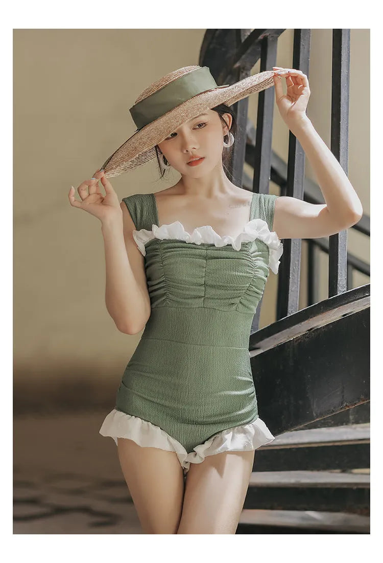 Black high-waisted one-piece swimsuit on a mannequin, showing quick-dry fabric and slimming cut.