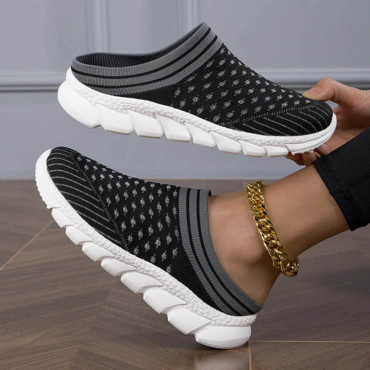 Women's black striped Flyknit slipper shoes with hollowed-out design on a viscose sole.