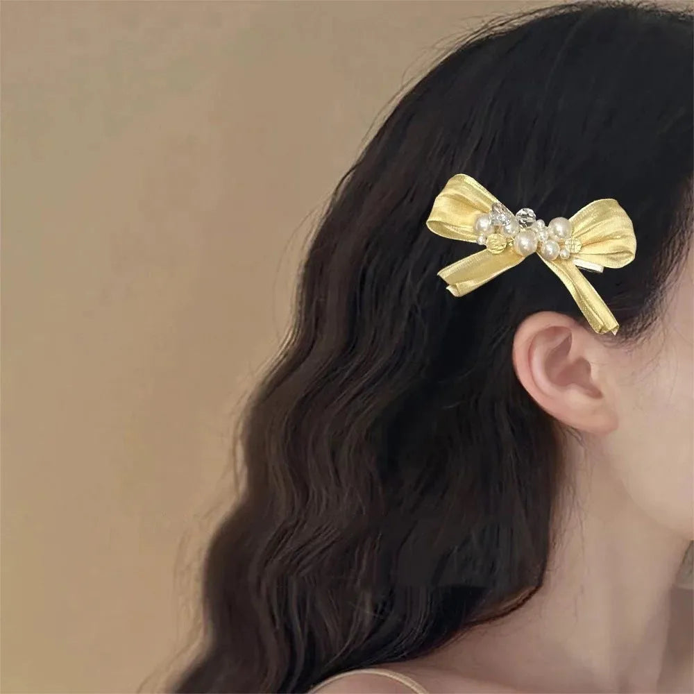 Yellow cloth bow hair barrette with rhinestone and pearl decoration on duckbill clip