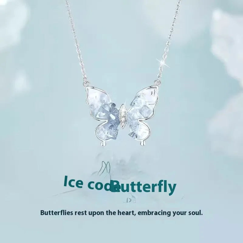 Close-up of a silver necklace with a detailed butterfly pendant on an O-ring chain.