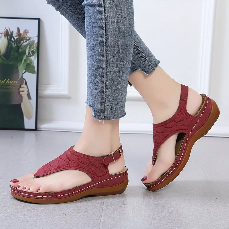Women's red wedge heel sandals with an adjustable back strap buckle.