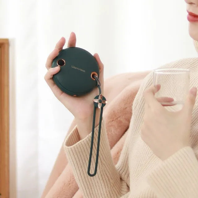 Green, pink, or white square 5000mAh hand warmer power bank with digital display next to charging cable.