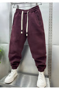 Summer men's solid colour polyester track sweatpants with zippered pockets and ankle ties, black, side view