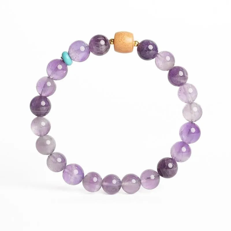 Close-up of a handmade purple amethyst crystal bracelet for women, showing smooth round beads.
