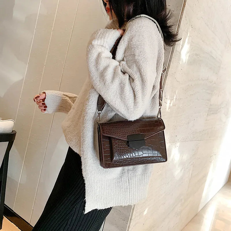 Vintage PU leather crossbody bag in black showing interior organisation for phones and wallets