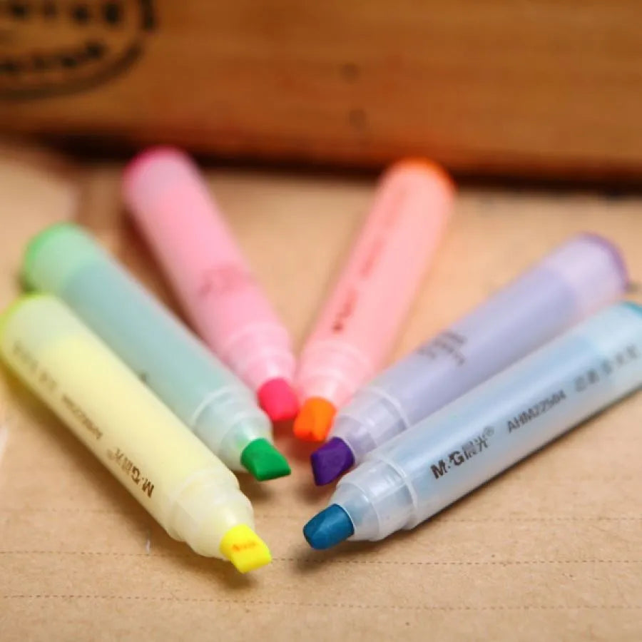 Set of six plastic barrel highlighter pens with chisel tips in six different colours, showing oblique pen shape.