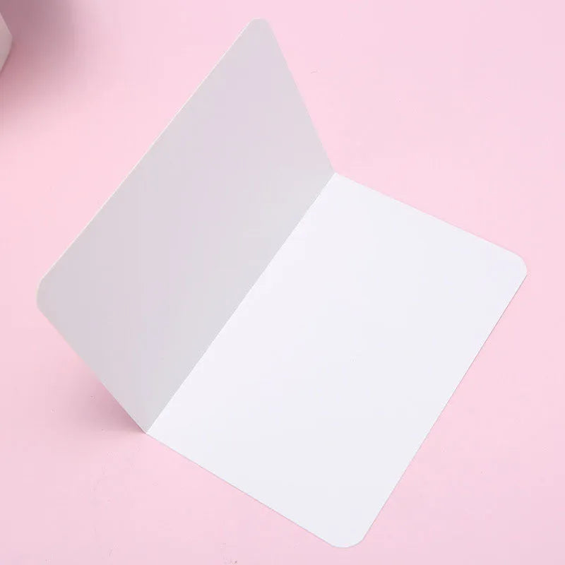 Pack of 100 blank folded kraft paper greeting cards in 10x15cm size, showing black, cowhide brown, and white colour options